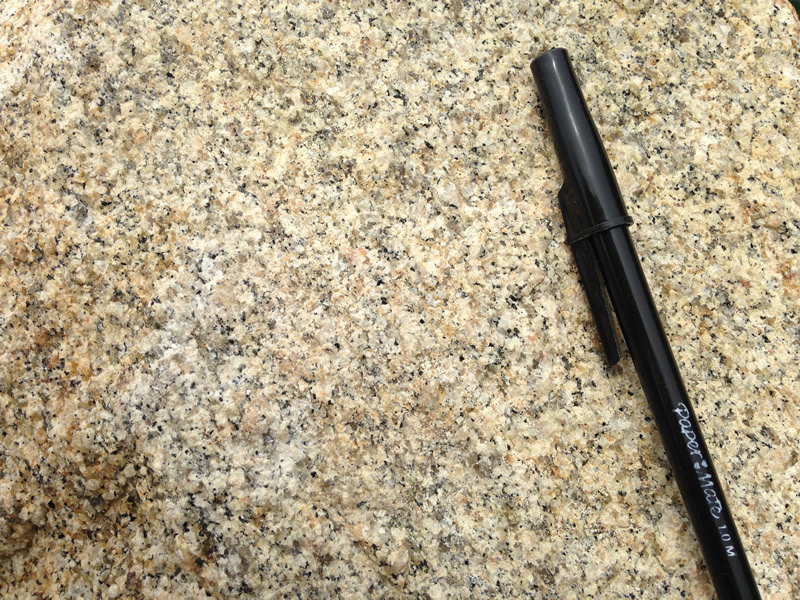 Figure 2: The surface of the granite, with a black ballpoint pen for scale.