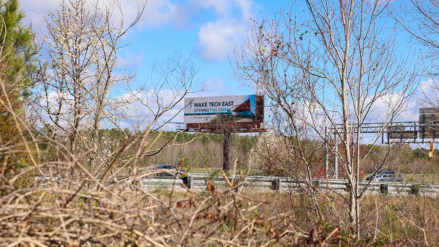 A highway billboard promotes the Wake Tech East campus
