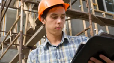 Photo of male construction worker holding a clipboard