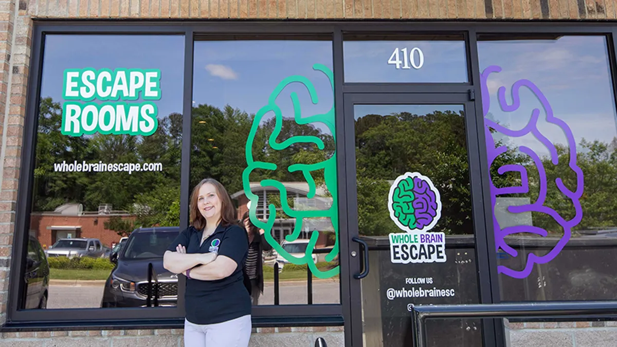 A graduate of the Entrepreneurship and Small Business Center stands outside her business.