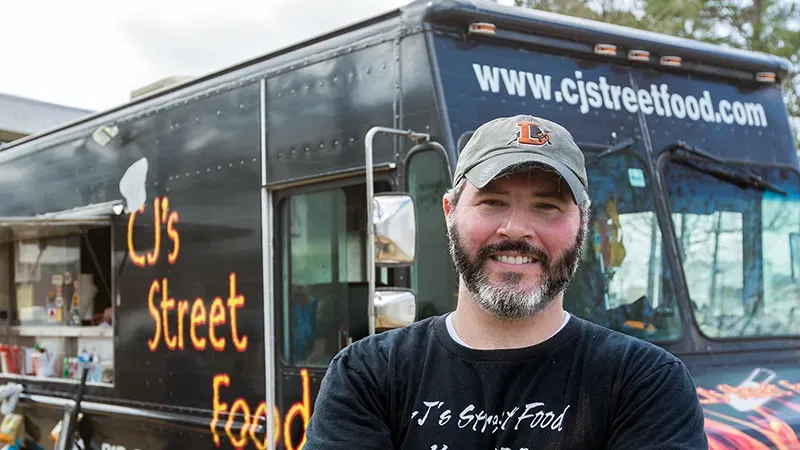 Image of a food truck owner in front of his business