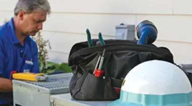 Image of an HVAC Technician repairing an air conditioning unit