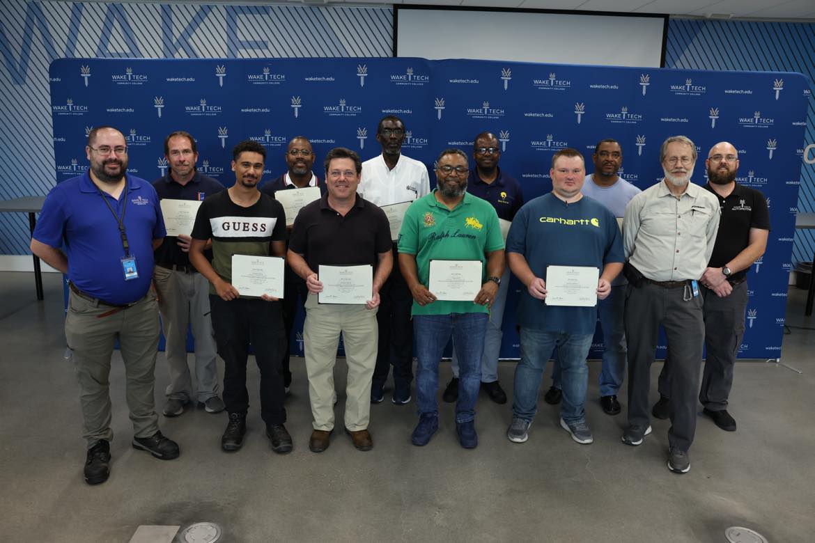 The first graduates of Wake Tech's Electric Vehicle Supply Equipment Field Technician Certification program pose for a photo.