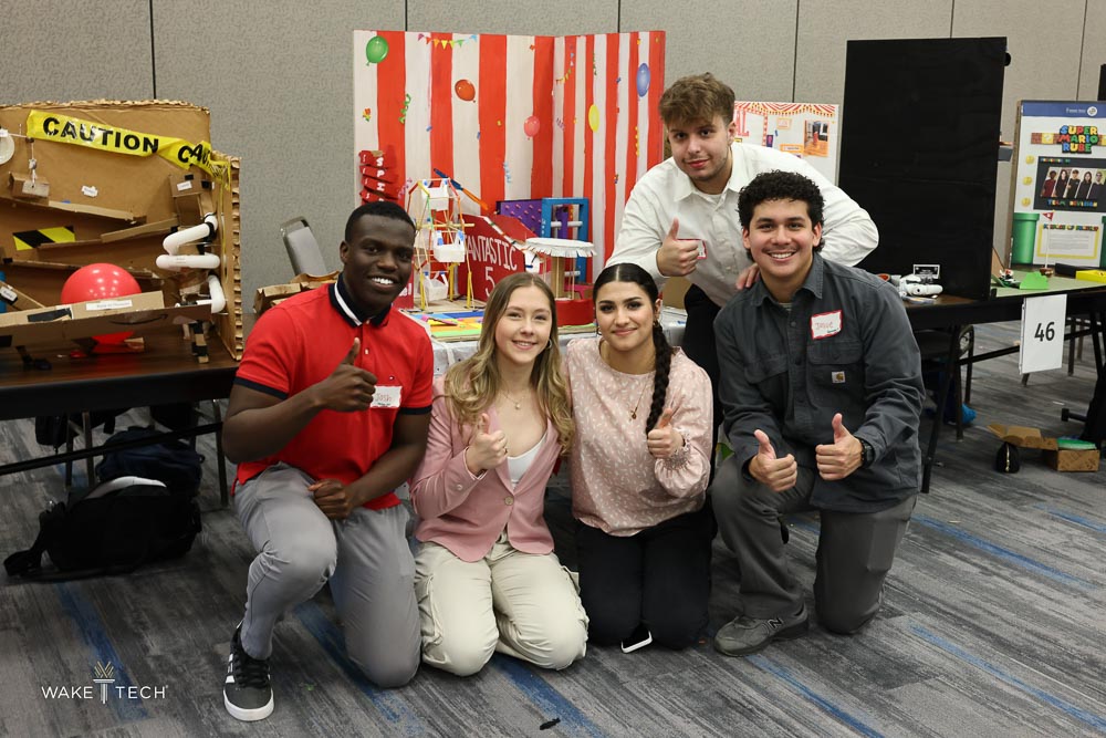 A Rube Goldberg Competition team poses next to its contraption.