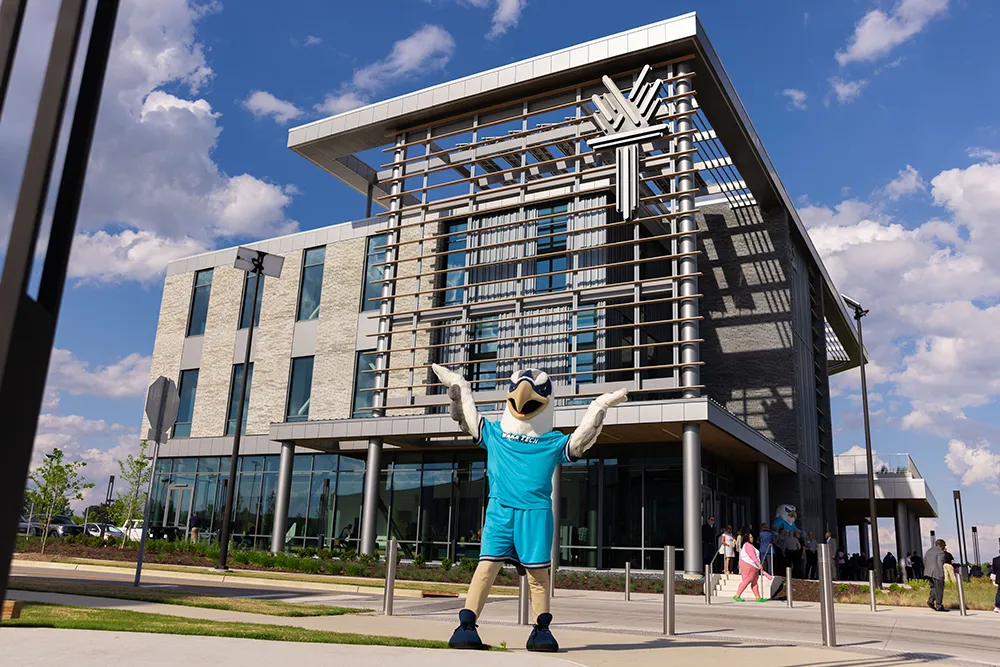 Talon, Wake Tech's mascot, poses in front of the Education and Innovation Center at Wake Tech East.