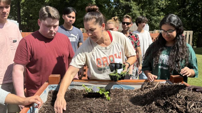 Instructor Lauren Musolf shows Wake Tech students how to plant seedlings.