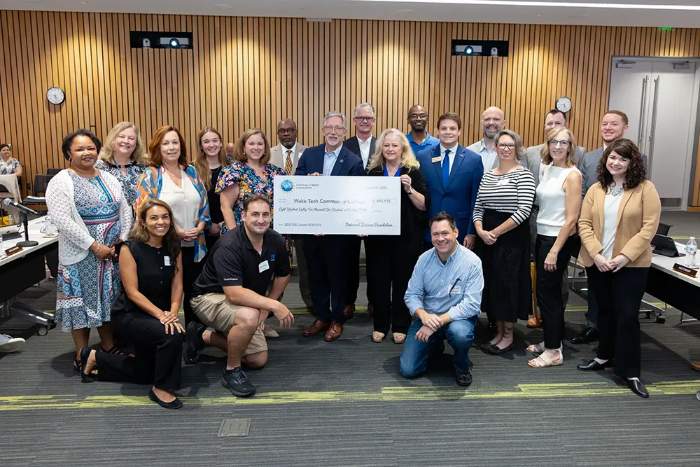 Wake Tech staff pose with a giant check to illustrate an NSF awarded to the college for a cybersecurity boot camp.