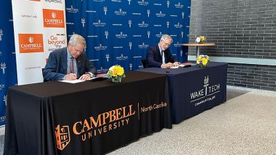 The presidents of Wake Tech and Campbell University sign a transfer partnership agreement.