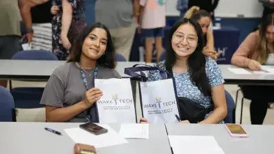 A new Wake Tech student celebrates the completion of the Eagle Start Summer Bridge Program with college staff.