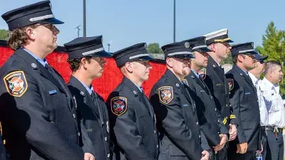 A flag flies from fire engine ladders during the groundbreaking ceremony for the Advanced Fire and Rescue Training Complex at Wake Tech East.