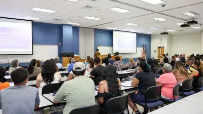 A new Wake Tech student celebrates the completion of the Eagle Start Summer Bridge Program with college staff.