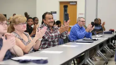 A new Wake Tech student celebrates the completion of the Eagle Start Summer Bridge Program with college staff.