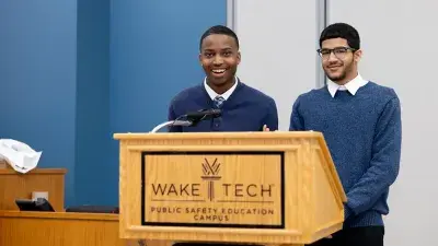 A new Wake Tech student celebrates the completion of the Eagle Start Summer Bridge Program with college staff.