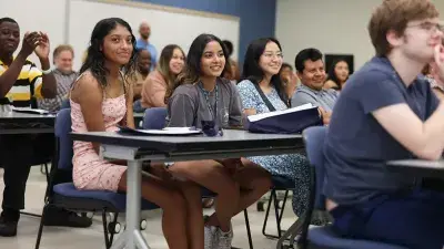 A new Wake Tech student celebrates the completion of the Eagle Start Summer Bridge Program with college staff.