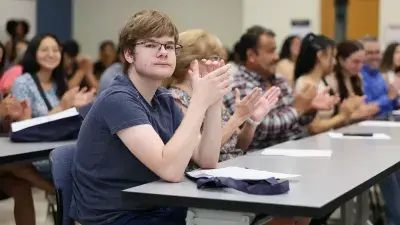 A new Wake Tech student celebrates the completion of the Eagle Start Summer Bridge Program with college staff.