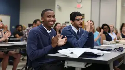 A new Wake Tech student celebrates the completion of the Eagle Start Summer Bridge Program with college staff.