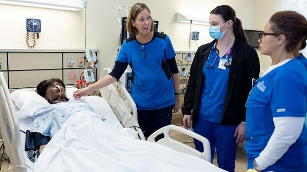 Kathy Spade discusses a patient simulation scenario to Wake Tech Nursing students.